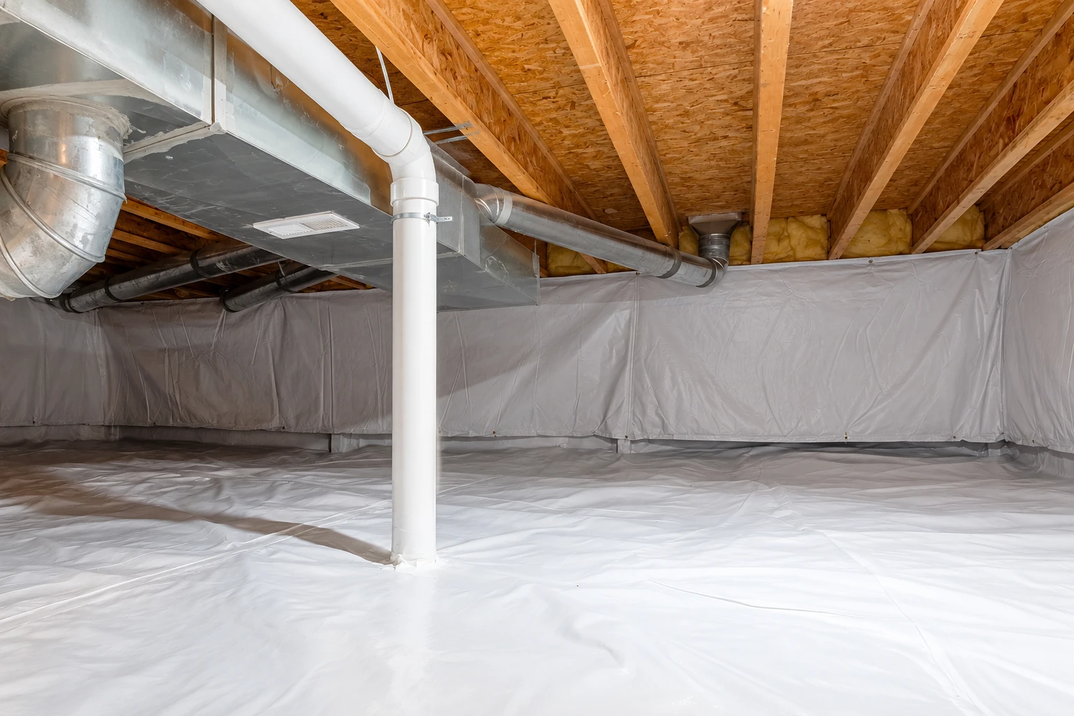 White plastic vapor barrier lines the floor and walls of a crawl space beneath exposed joists and ductwork.